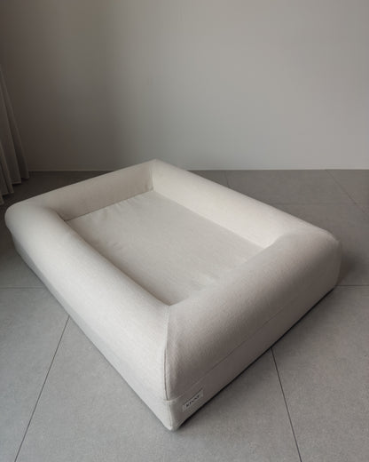 The KINNE Bed in Oat, three-quarter view